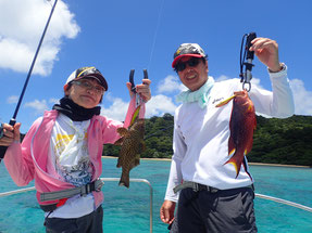 海のボートの上で魚を持ってる親子