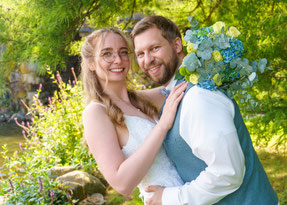 Hochzeitsfotografie von Foto Schuh: Ein glückliches Brautpaar lacht gemeinsam in die Kamera, festgehalten in einem natürlichen und eleganten Stil.