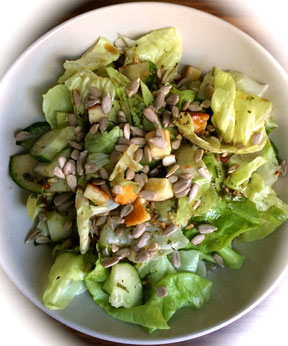 Grüner Salat mit Grillkäsewürfeln und Sonnenblumenkernen