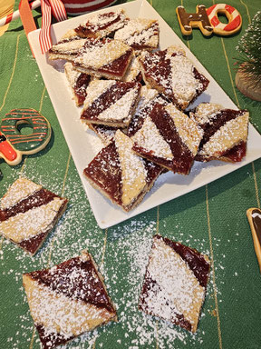 Linzer Schnitten mit Marmelade und Puderzucker auf Teller angerichtet