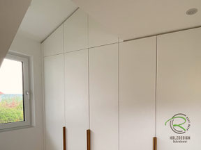 Dachschrägenschrank mit einem Kleiderschrank angepasst an die Raumabmaße in weiß und Eichen Griffleisten von Schreinerei Holzdesign Ralf Rapp in Geisingen
