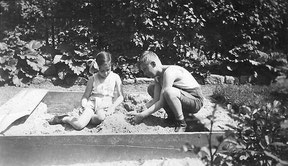 Schwarzweißfoto: zwei Kinder im Sandkasten