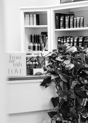 Detailansicht eines Raumes im Salon mit antik anmutendem Spiegel und Produkten im Hintergrund.
