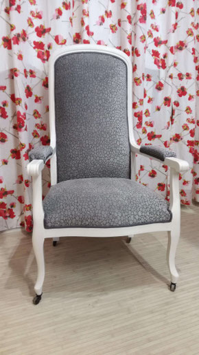 Fauteuil Voltaire bois peint en blanc et recouvert d'un tissu faux uni dans les tons de gris finition galonnée