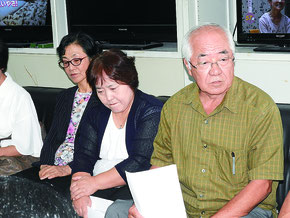 記者会見で訴訟への参加を那覇地裁に申し立てたと発表する平安座会長(右端)=5日、県庁