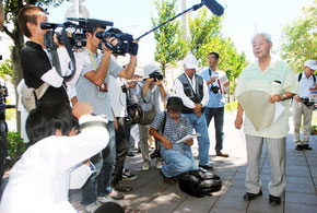 保守系教科書に反対する「子どもと教科書を考える銃民の会」の仲山共同代表を囲む報道陣=23日午後、市教委前