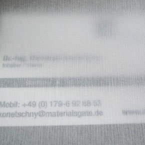 Transluzente Verbundfolie aus weißem Papier und transparentem Kunststoff erzeugt einen unscharfen Hintergrund.