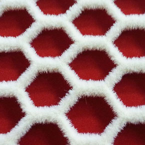 Textiles Netz mit sechseckigen Maschen. Das Netz ist mit weißen Fasern beflockt und liegt vor einem roten Hintergrund.
