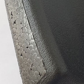 Schwarzer Kunststoff mit haptischer Oberflächenstruktur.