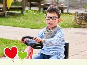 Phil, 9 Jahre, fährt im Hof des Haus St. Martin Kettcar