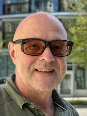 Mann hat eine Überbrille zu seiner normalen Brille.