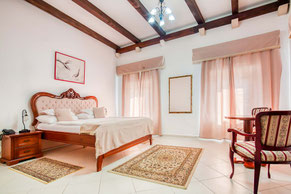 Spacious family suite at Palata Venezia Ulcinj featuring elegant decor, large bed, and bright interior.