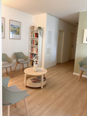 Empfangsnaher Wartebereich der Psychotherapiepraxis mit Bücherregal (psychologische Lektüre)