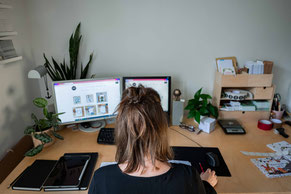 Frau mit braunem Haar arbeitet am Schreibtisch