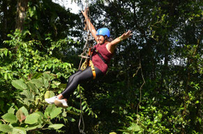Visitante disfrutando del canopy en Arenal Ecoglide con salto tipo Tarzan Swing sobre el bosque tropical cerca del Volcán Arenal.