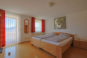 Doppelbett und Zugang zum Balkon