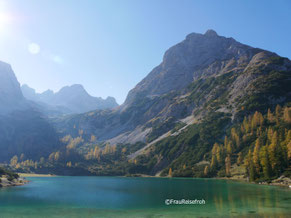 See, Berge und Bäume im Sonnenlicht