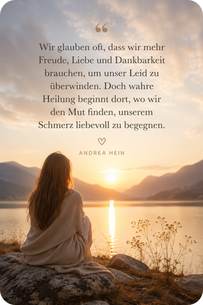 Zitatbild zum Powertalk „Heile den Schmerz in Dir“ von Andrea Hein. Eine Frau sitzt in einer ruhigen Naturlandschaft am Wasser und lädt dazu ein, seelischen Schmerz mit Mitgefühl anzunehmen und innere Heilung zu erfahren.
