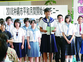 中学生大使を代表してあいさつする奥平茉那さん(美里中学2年)=1日午前、沖縄市役所