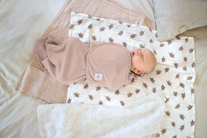 Schlummerndes Baby im LÄSSIG Pucksack auf LÄSSIG Musselin Tüchern