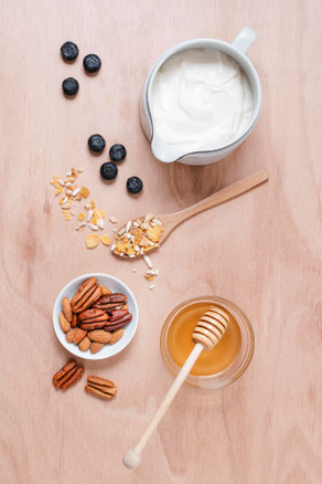 Honig, Nüsse und Milch auf einem Holzbrett.