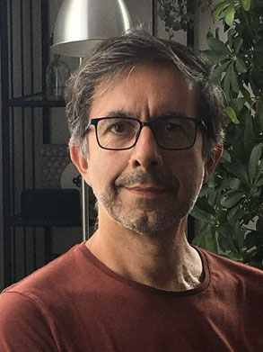 Portrait rapproché de Philippe Colin, la moitié gauche du visage éclairé par la lumière d'une fenêtre