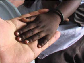 die vierjährige Tocher von Jairus Orangi legt ihre Hand in die Hand von Hans Gnann