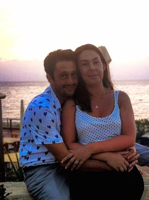 coppia abbracciata che sorride sfondo spiaggia