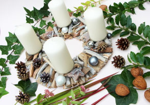 Adventskranz aus weißen Treibhölzern mit weißen Kerzen. 