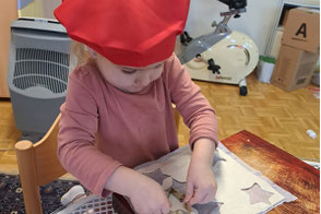 Kind mit roter Kappe sticht Kekse aus
