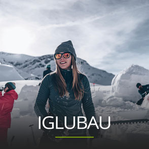 Frau mit einer Schneesäge vor einem Iglu, Schriftzug: IGLUBAU