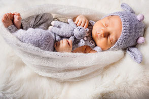 Nestschutz: Baby schlaeft mit Kuscheltier in der Arztpraxis Gauting.
