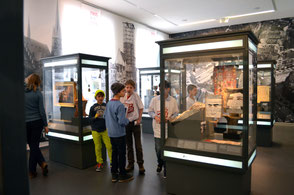Zwei peer-Teamer und zwei Kinder sprechen über die Themen einer Ausstellung zur Stadtgeschichte.  