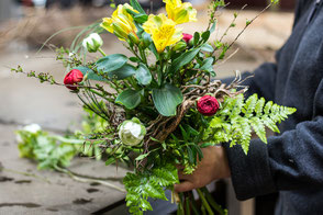 Binden von Blumengestecken und pflanzen von Kräuter-Setzlingen. Arbeitstraining in der Gärtnerei. 