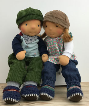 Zwei grosse Stoffpuppen sitzen nebeneinander die Puppen sind handgemacht und für Kinder zum Spielen geeignet