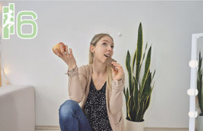 Julia Emberger isst eine Tafel Schokolade, hält aber auch einen Apfel in der Hand
