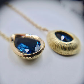 Pendants d'oreilles or jaune 18k serties de 2 topazes blue London taille poire suspendues à des puces d'oreilles au motif végétal sculpté avec délicatesse suspendues à 2 chainettes