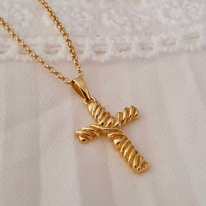 Collier avec croix religieuse dont le motif végétal entoure l'ensemble de la croix