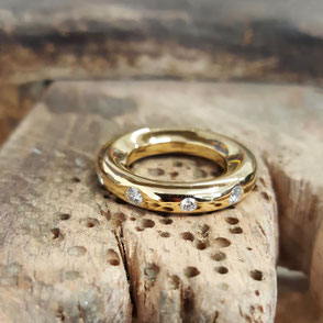 bague jonc sur mesure en or et diamants. La bague présente une forme arrondie, épaisse et lisse au design sobre.