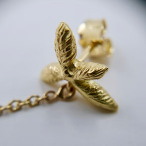 Pendants d'oreilles or jaune 18k serties de 2 topazes blue London taille poire suspendues à des puces d'oreilles au motif végétal sculpté avec délicatesse suspendues à 2 chainettes