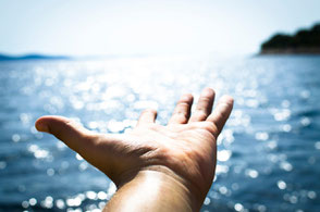 Ausgesreckte, helfende Hand am Wasser