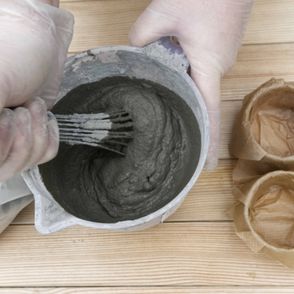 Mixing concrete for the DIY Concrete Candle Holder Tutorial, a wonderfully easy concrete diy with recycled moulds and baking paper to create a tree bark texture!