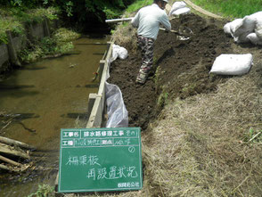 崩壊した排水路のコンクリート製擁壁を修理している写真