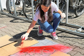 Die Schablone mit Sprühfarbe oder Sprühkreide besprühen