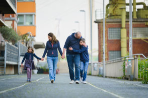 Fröhliche Familie läuft gemeinsam Hand in Hand durch den Medienhafen in Düsseldorf