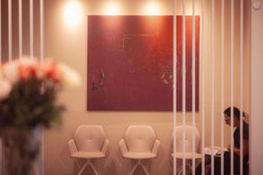 Wartebereicht in Kanzlei mit weiblicher Person im Hintergrund