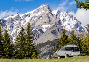 Wohnwagen auf Naturwiese vor Alpen 2026