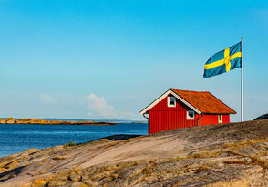 Schweden Flagge mit rotem Haus am Meer 2026