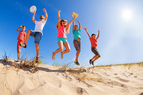Fröhliche Kinder am Strand auf einer Schulreise oder Klassenfahrt, gut versichert mit der Schüler-Reiseversicherung der ERGO