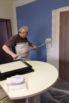 Ein Maler streicht die Wand im ERV-Büro von Ina Bärschneider